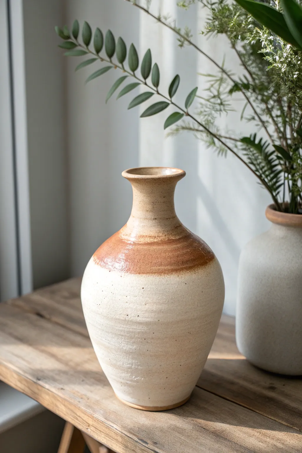 Rim-dipped glaze with soft, intentional runs adds effortless elegance to a simple rounded vase.