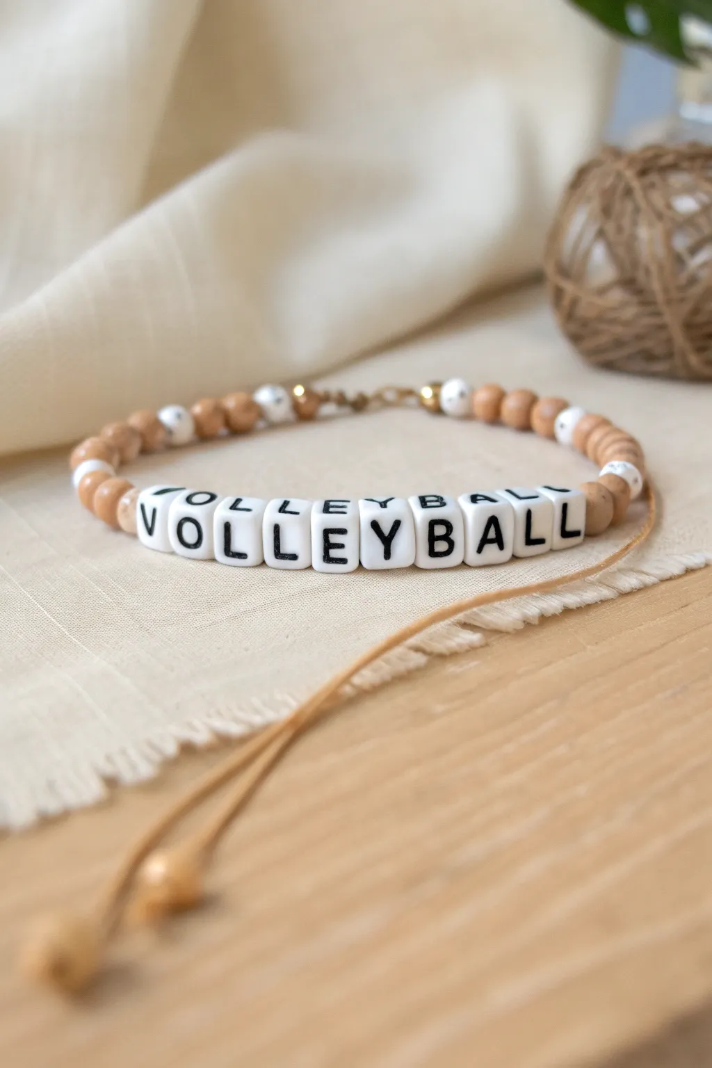 Minimalist volleyball heishi bracelet with clean letter bead center and soft neutral clay tones.