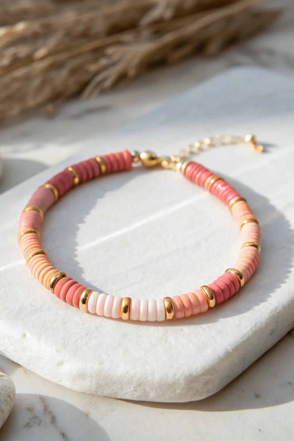 Soft ombré heishi beads with spaced gold accents for a minimal yet striking clay bracelet.