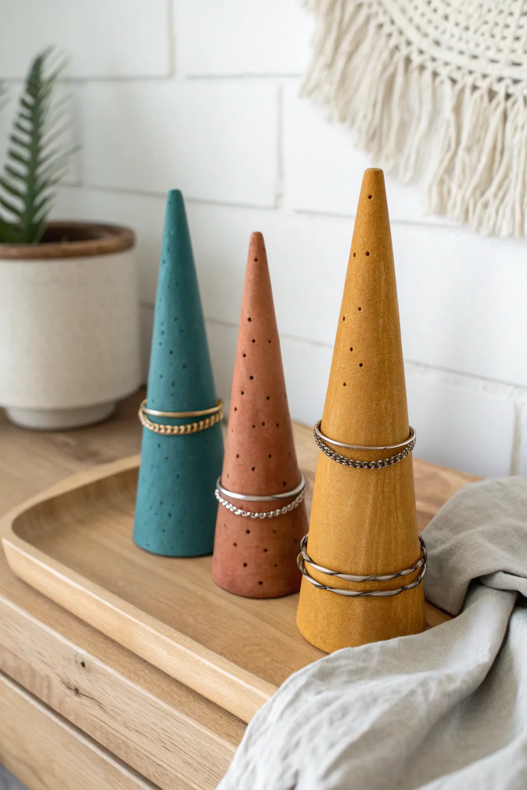 Three colorful cone ring stands with handmade textures, a simple Scandinavian boho shelf display.