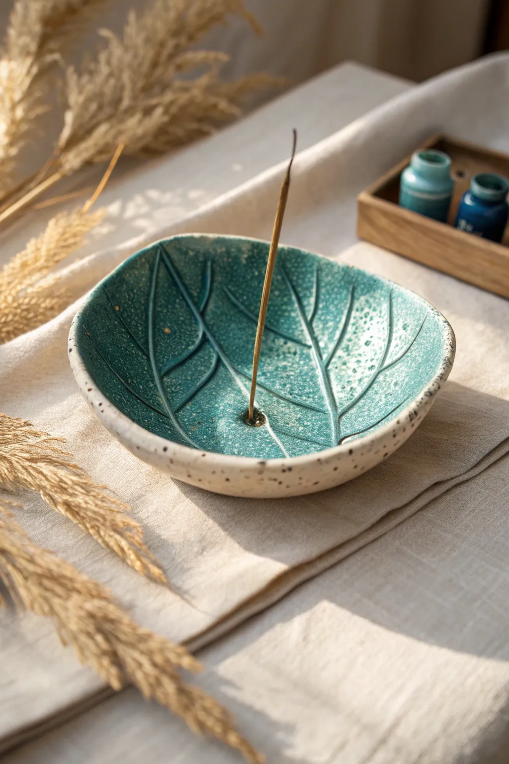 Leaf-shaped air-dry clay ash catcher in bold teal, minimalist Scandinavian style with boho warmth.