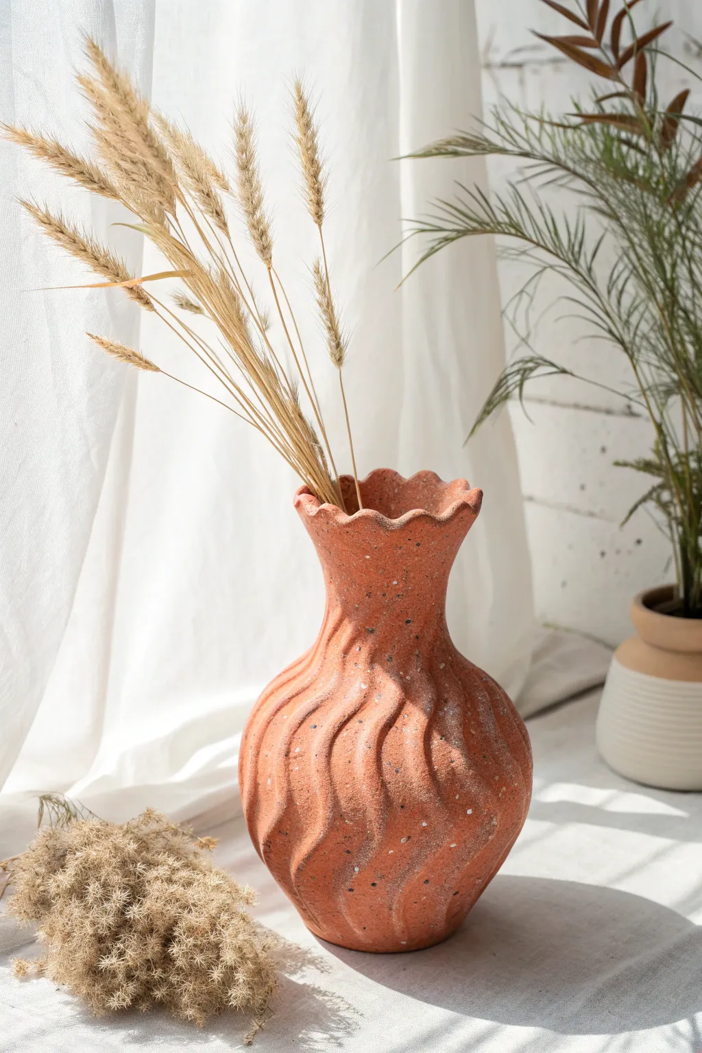 Organic air-dry clay vase with a wavy rim, bold color, and soft pampas for minimalist boho charm