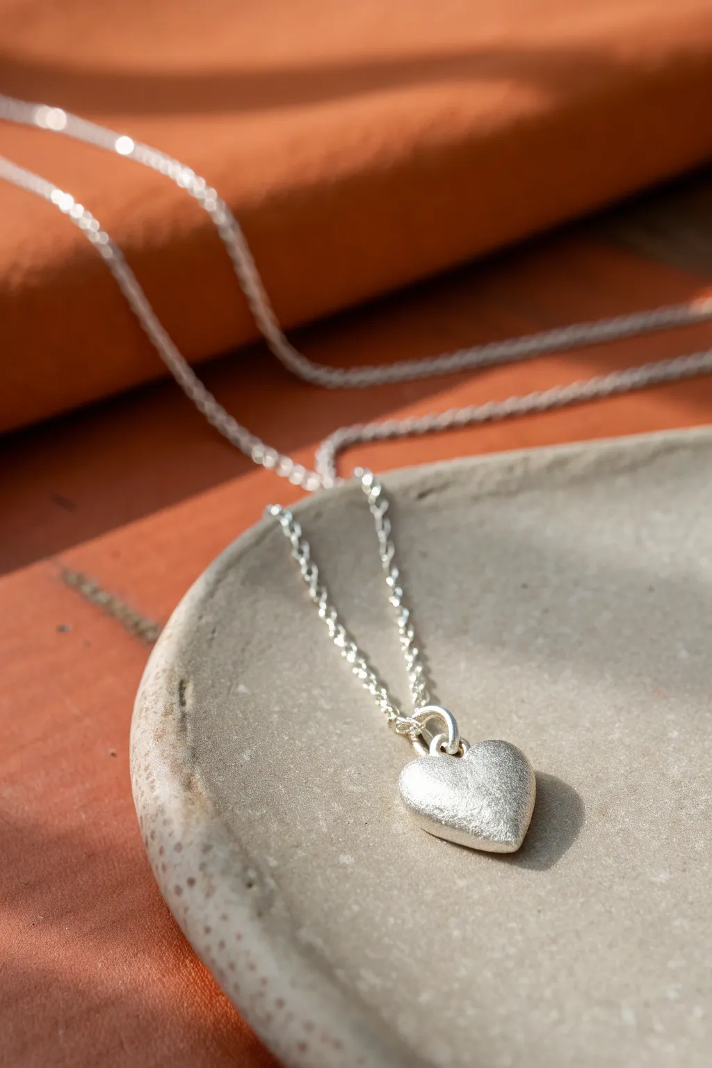 Tiny satin silver clay heart charm on a delicate chain, minimal and boho, perfect for beginners.