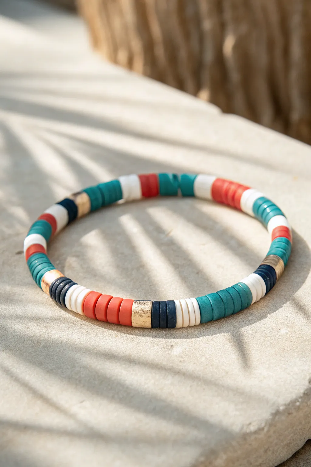 Bold color-blocked Heishi bracelet in teal, white, coral, and navy, simple and striking.