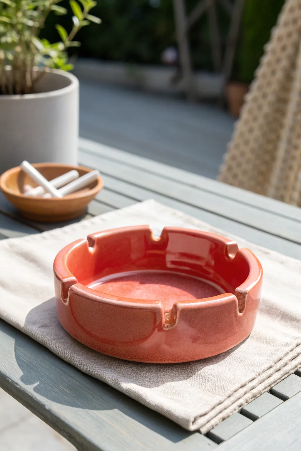 Bright four-rest ceramic ashtray centerpiece, minimalist patio styling with bold cheerful glaze.