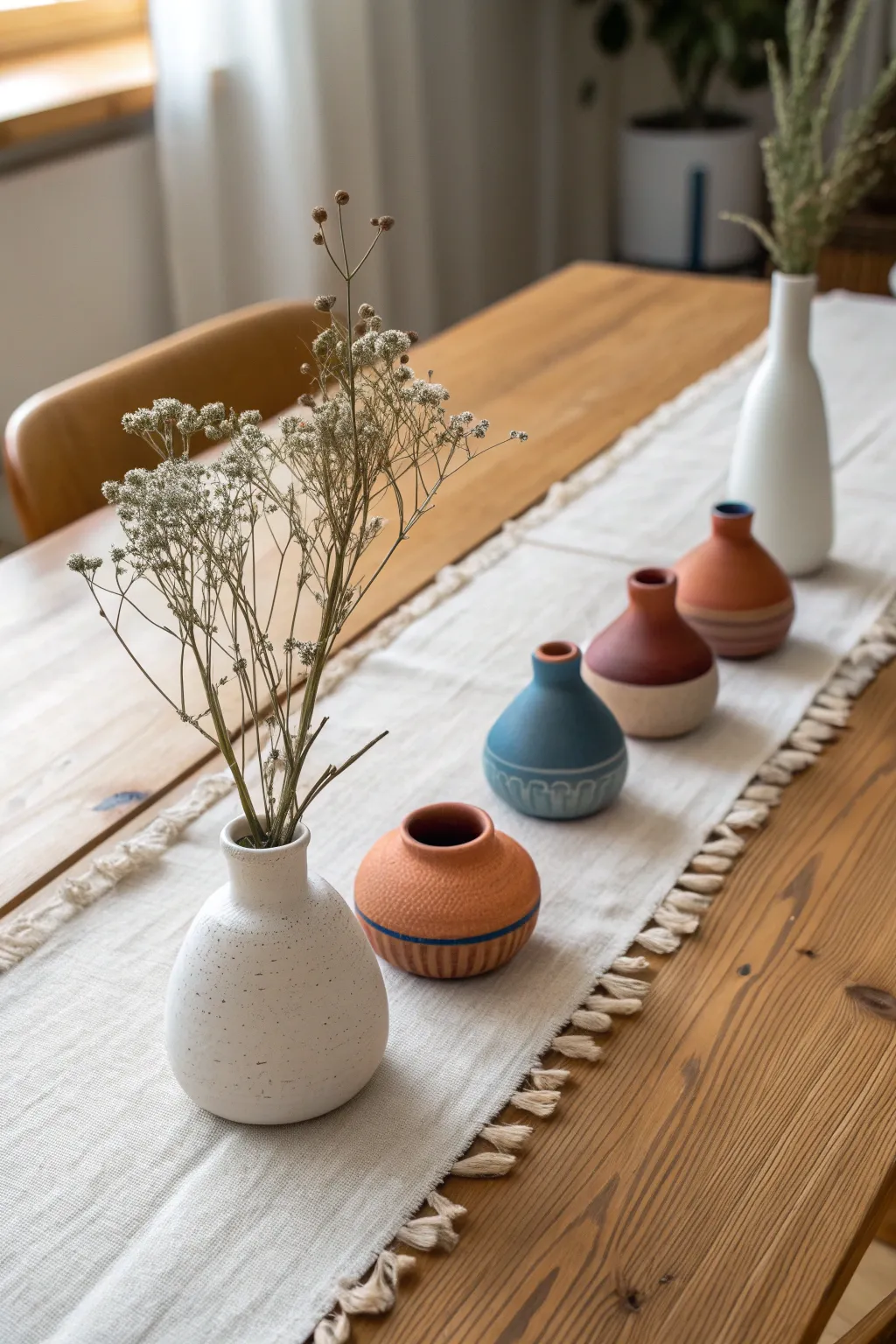 Simple bud vase lineup: tiny handmade ceramics with single stems for an airy dining centerpiece.