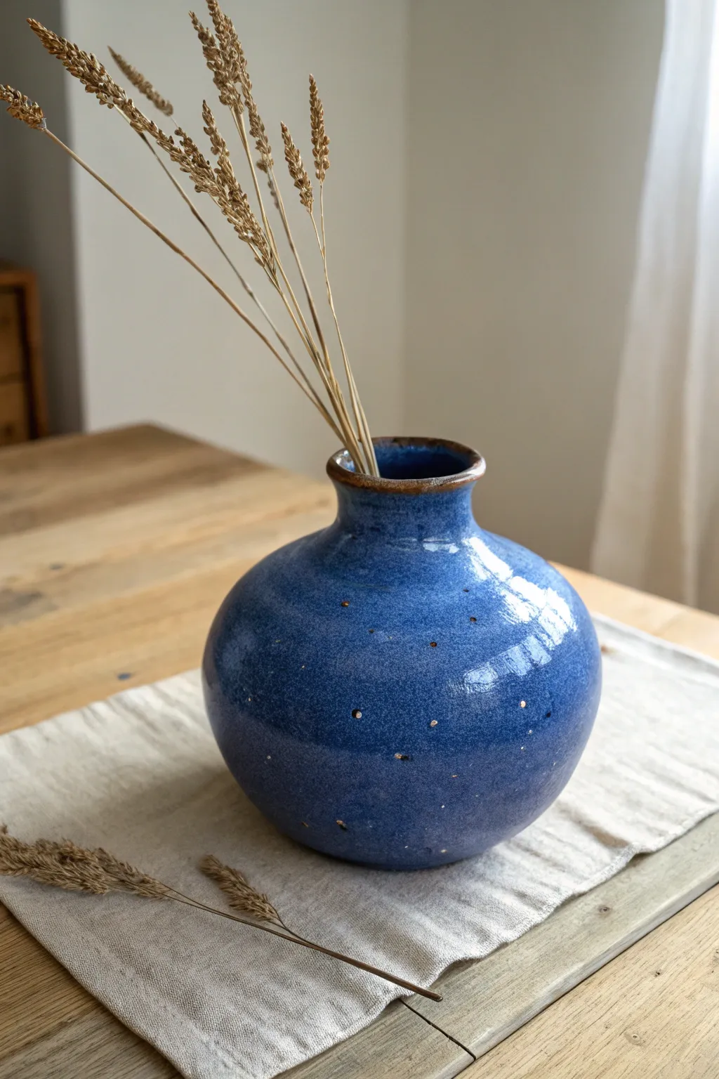 Rounded belly vase with a narrow mouth, bold color, and cozy dried stems for minimal styling.
