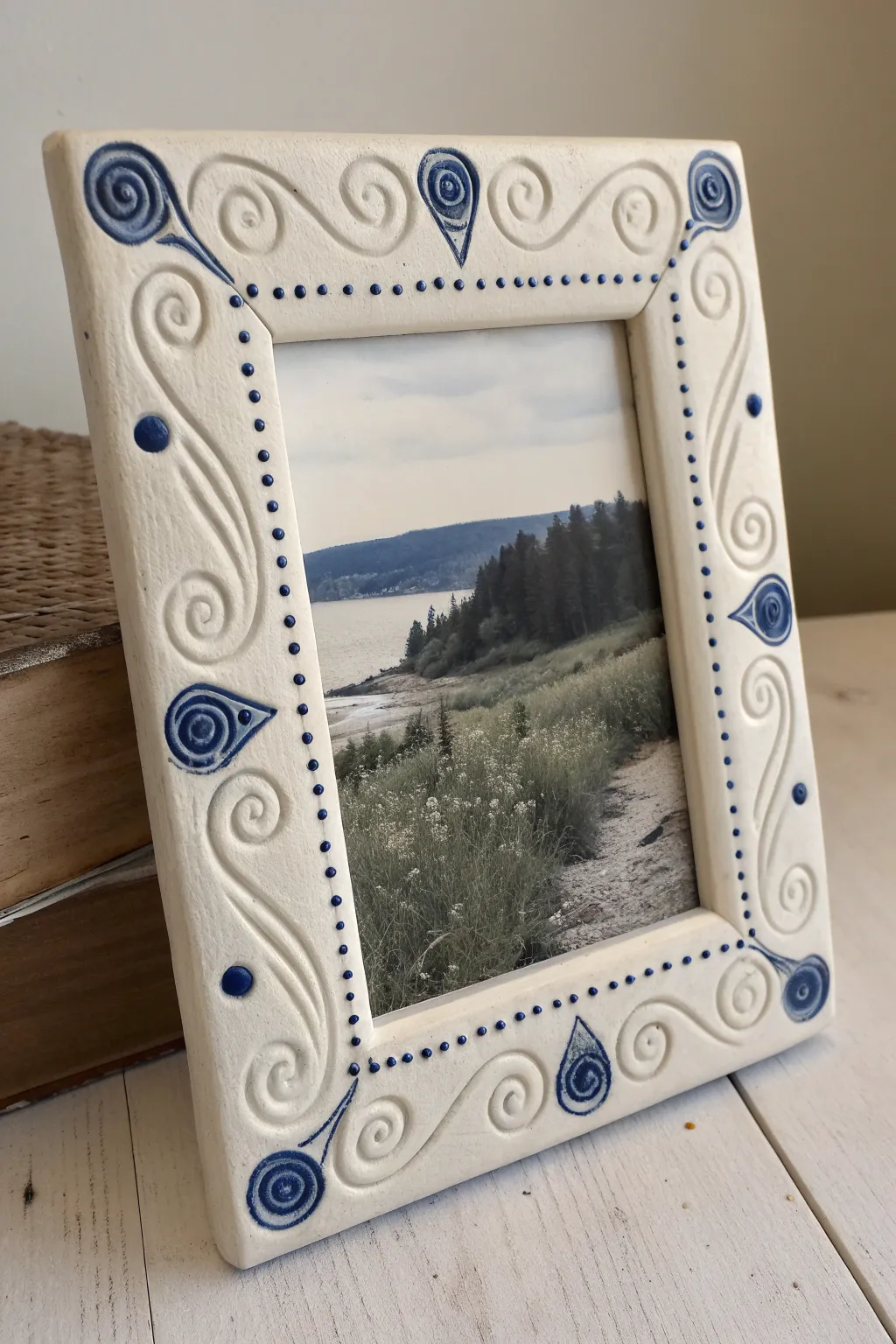 Minimal coil-decorated clay frame with bold cobalt accents and a crisp black-and-white photo