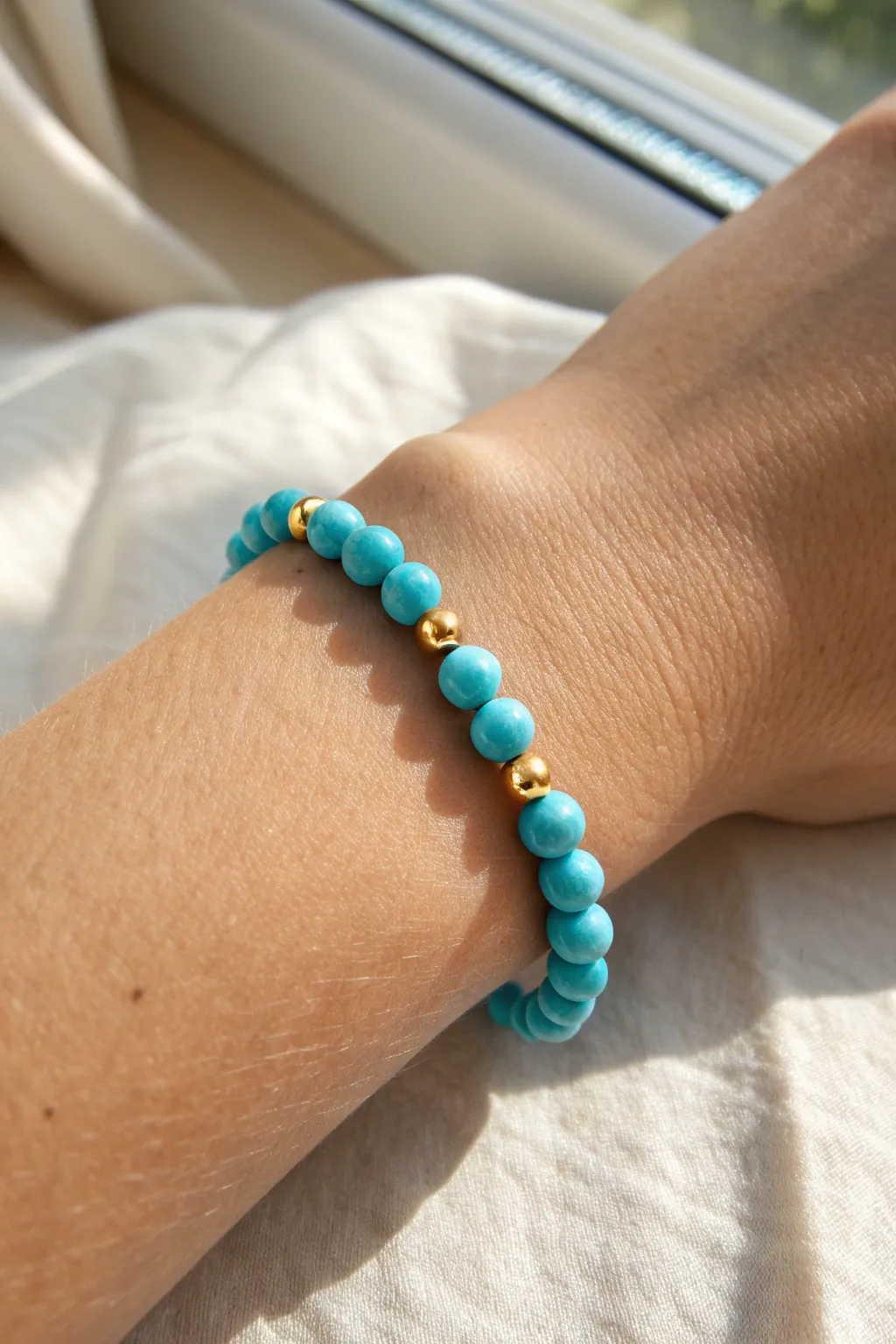 Turquoise clay bead bracelet with gold spacers, minimalist boho rhythm and warm glow.