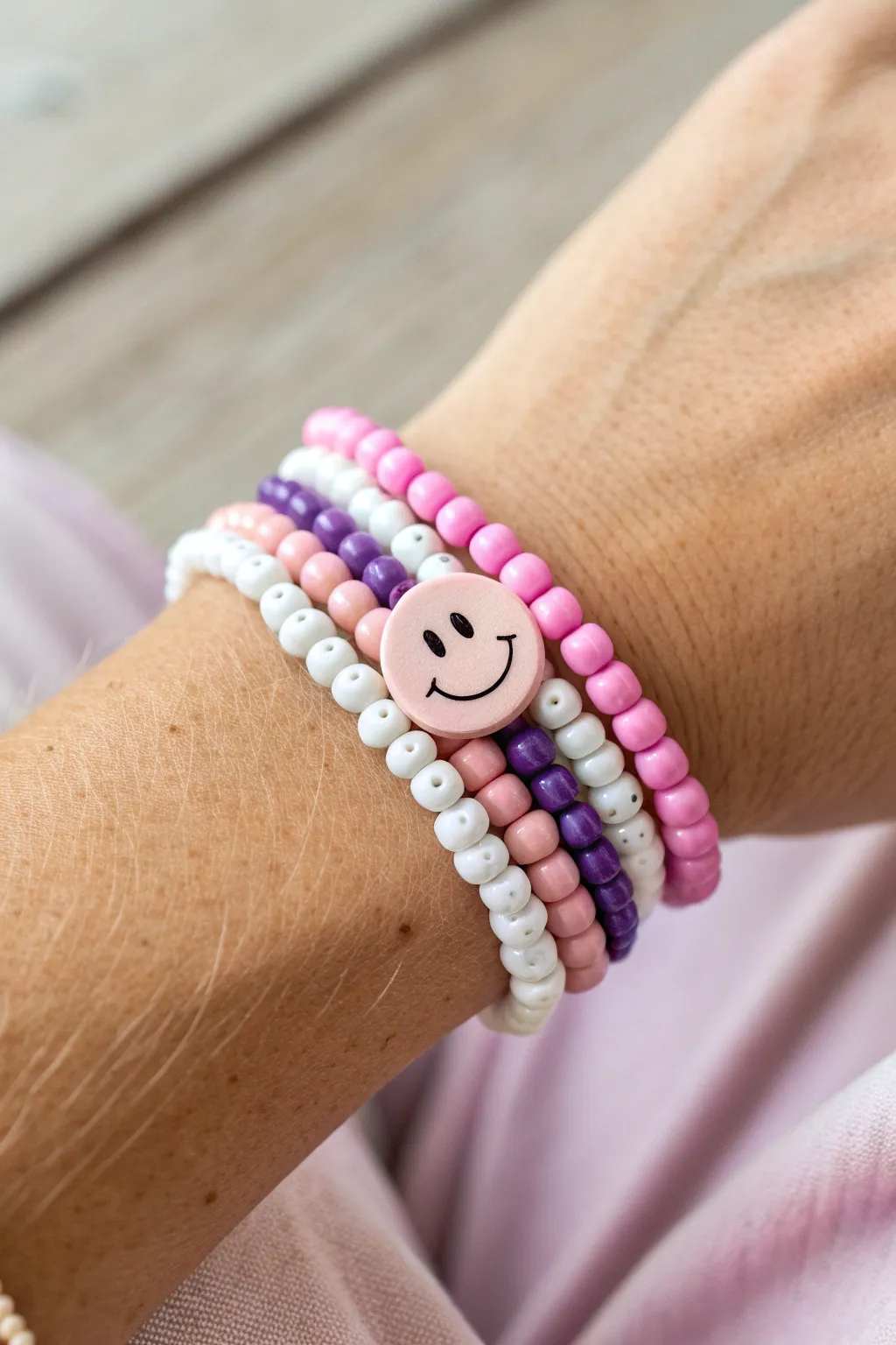 Preppy pink and purple heishi stack with a centered smiley bead, sporty pretty and handmade.