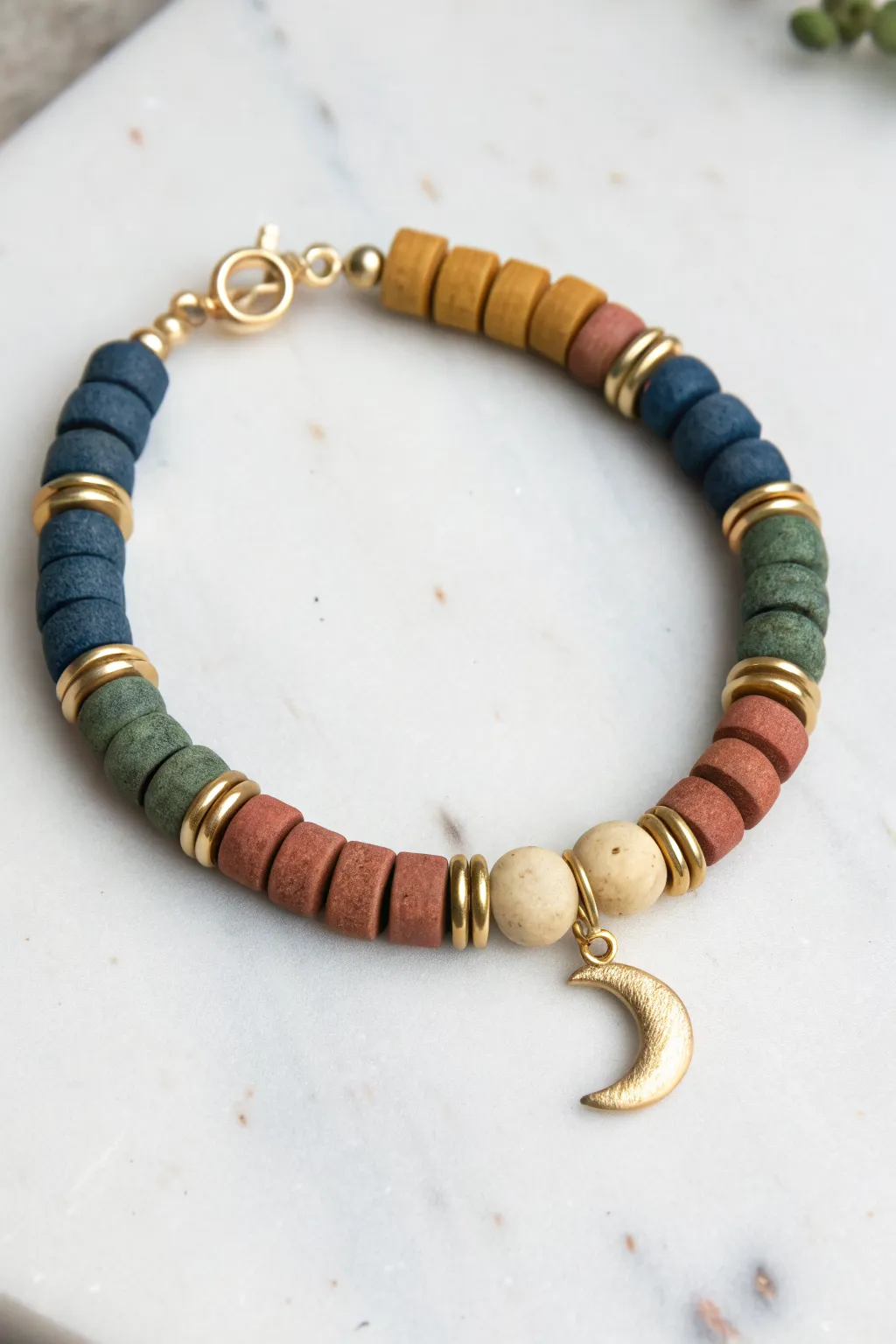 Bold color-block clay discs, sleek spacers, and a centered charm for a clean boho finish.
