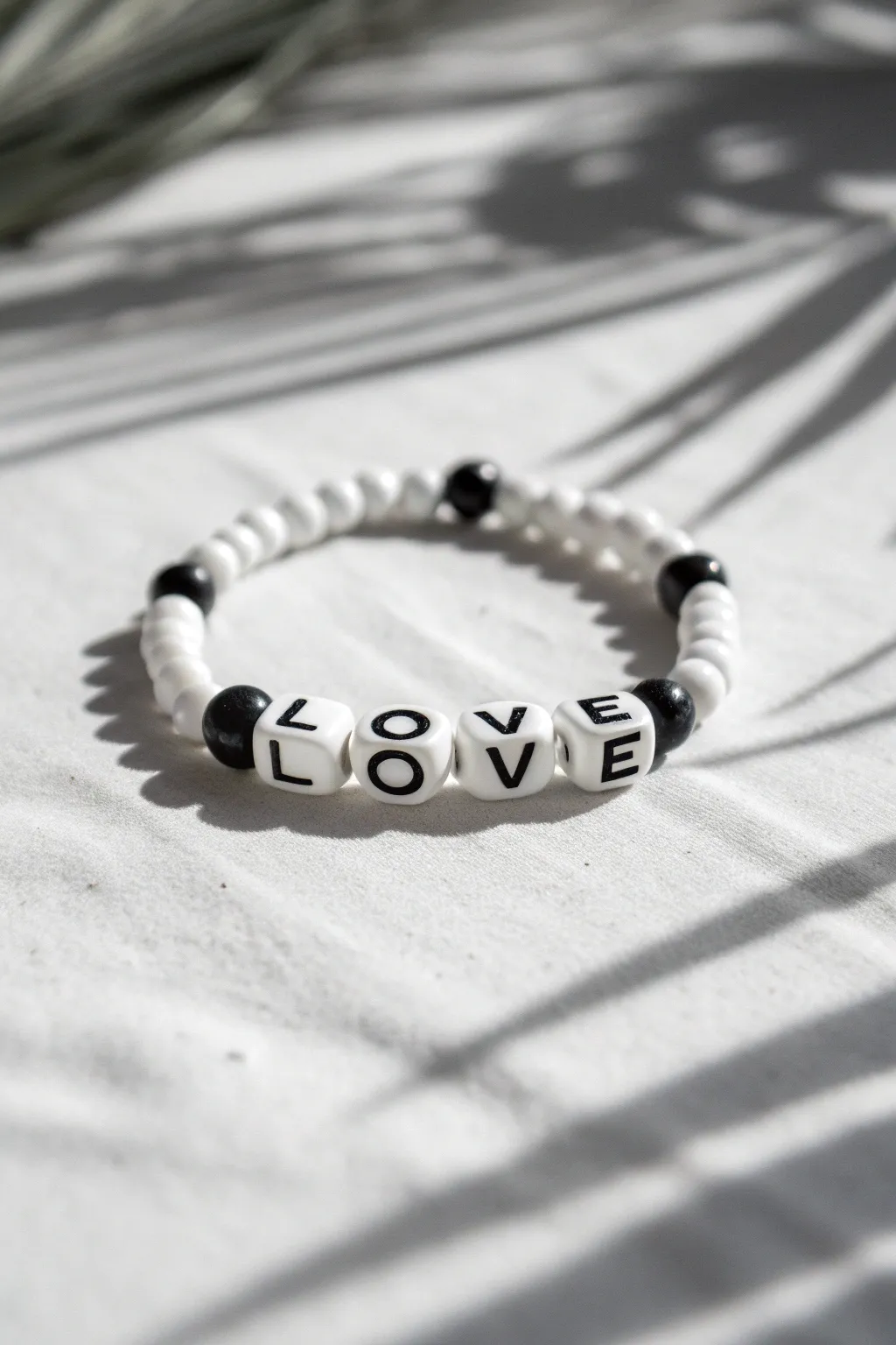 Black and white heishi bracelet with bold LOVE center, minimalist style and handmade charm