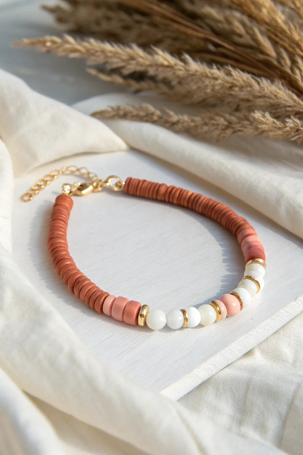Soft ombre heishi bead bracelet fading blush to terracotta, minimalist Scandinavian boho vibe.