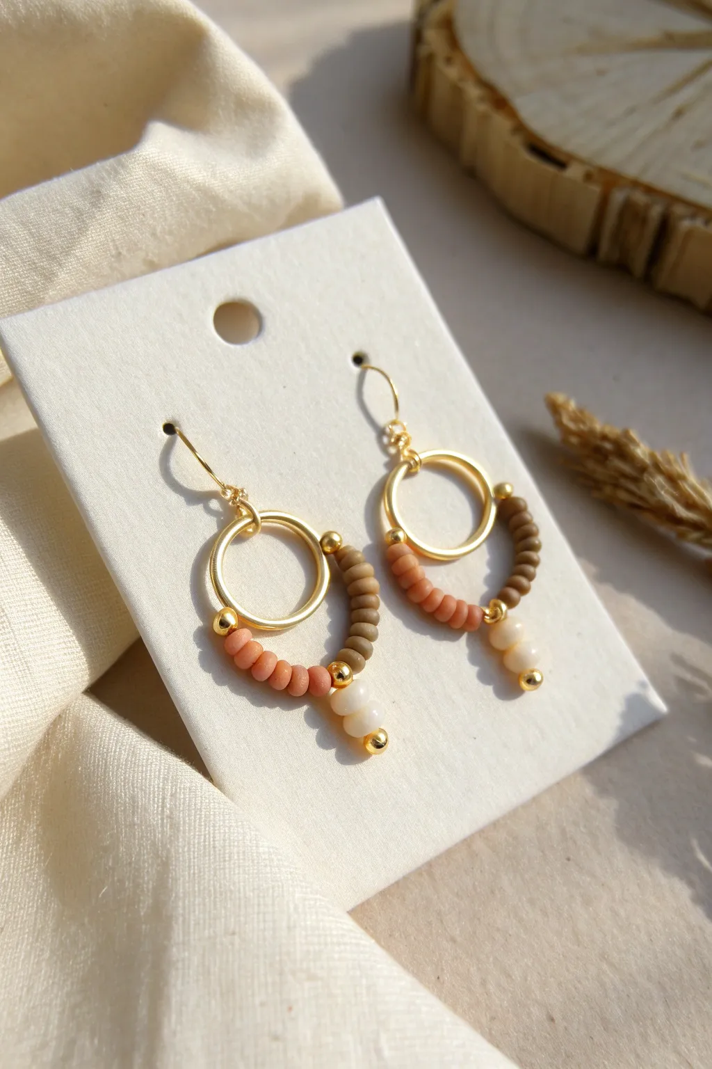 Minimal neutral clay bead huggie hoops in warm heishi tones for a clean, modern boho look