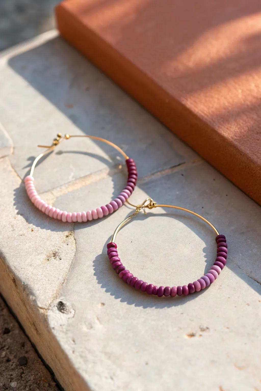 Soft ombré heishi bead hoop earring in blush-to-berry tones, minimal and handmade chic.