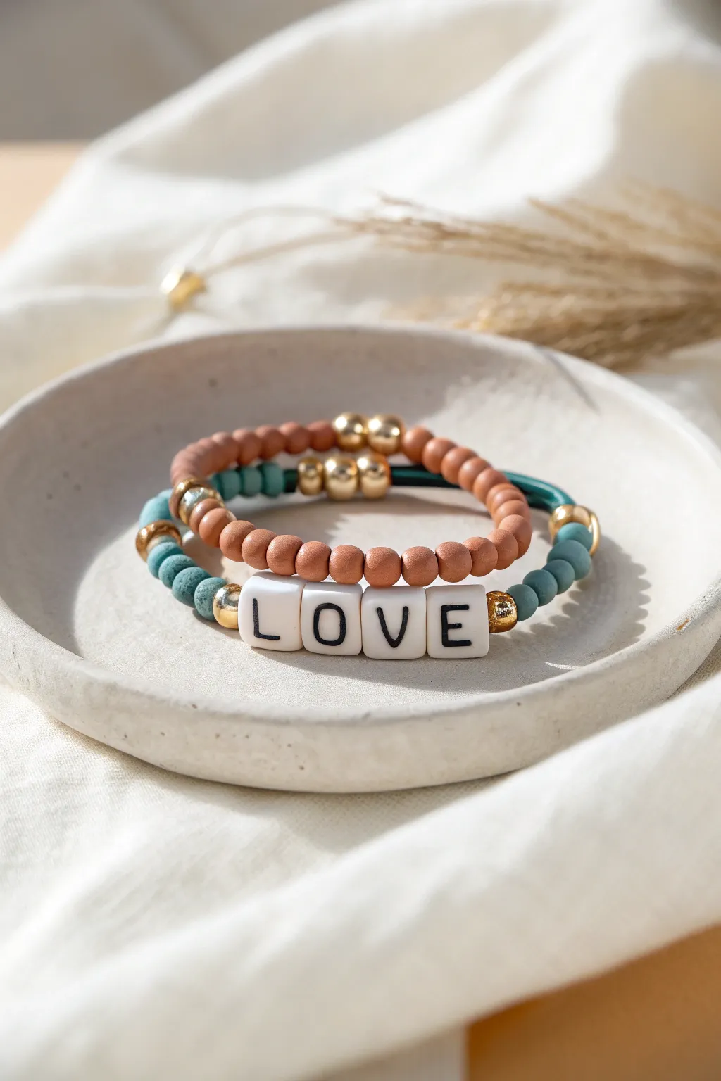 Three simple clay bead bracelets, one with centered letter beads, for an easy personalized boho look.