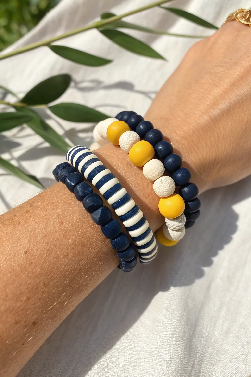 Varsity team-color clay bracelet stack: bold navy, stripes, and tiny accent pops on a wrist