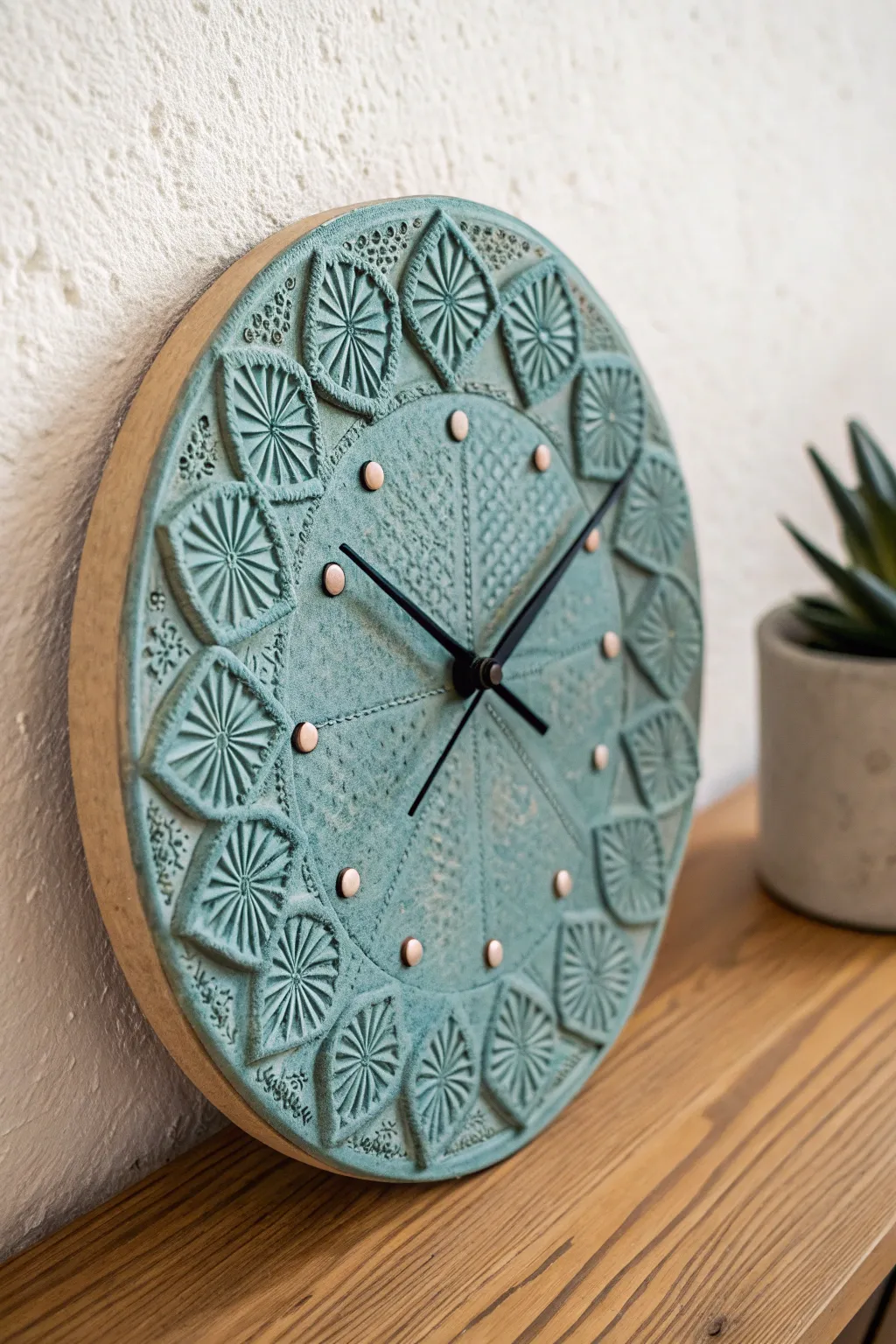 Rustic stamped ceramic clock in teal glaze with clean white hour dots, minimalist boho vibe.