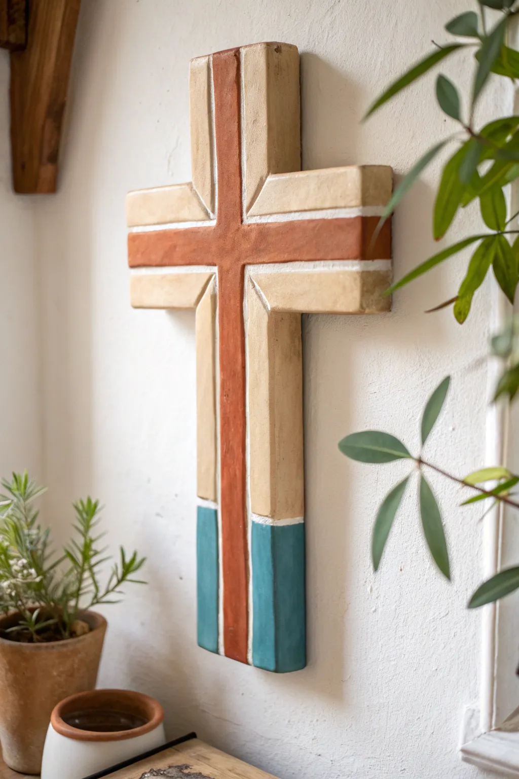 Minimal color-block clay cross in warm neutrals with a bold accent for a modern wall display