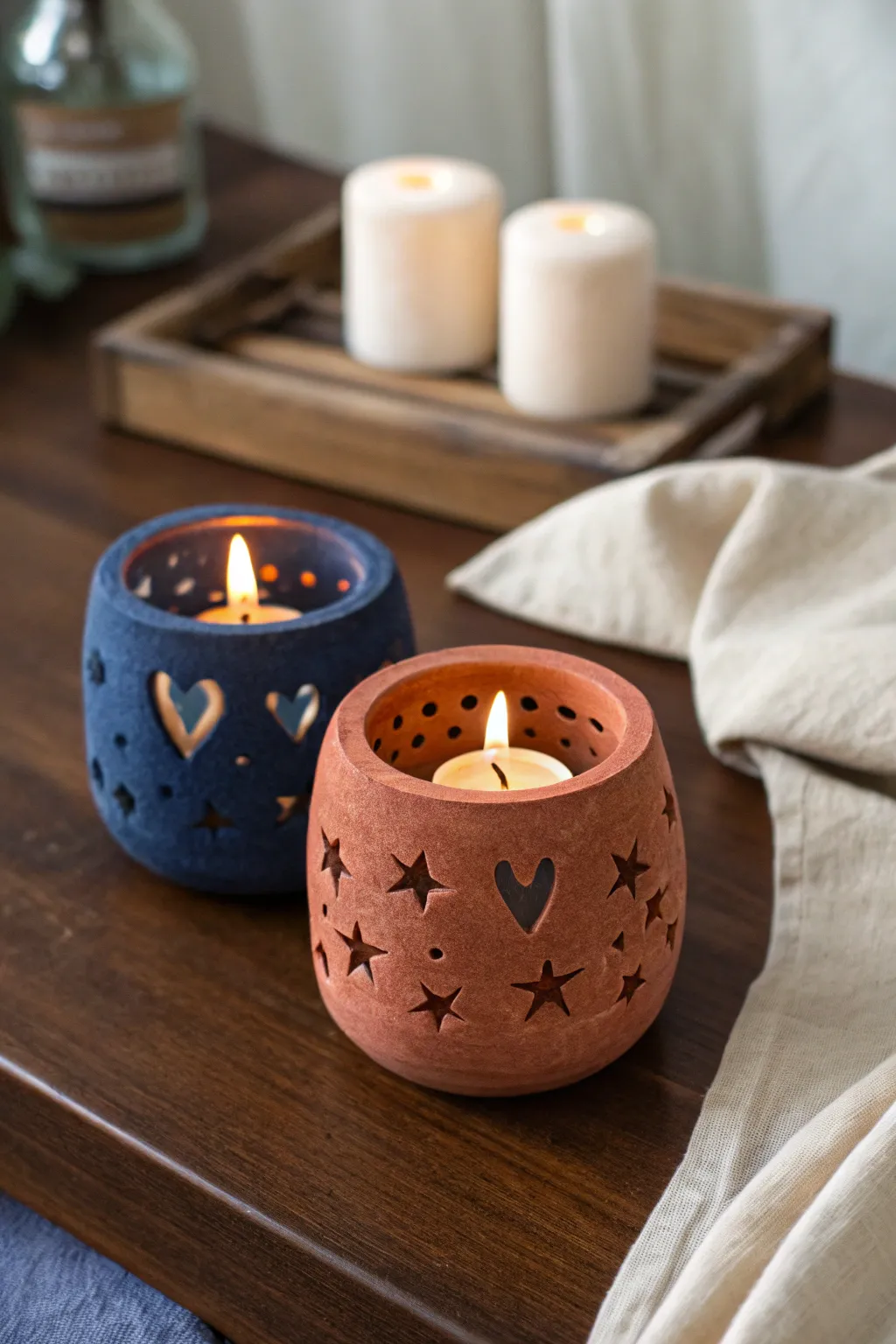 Cozy date-night glow: matching clay tea light holders with simple cutouts, warm and minimal.