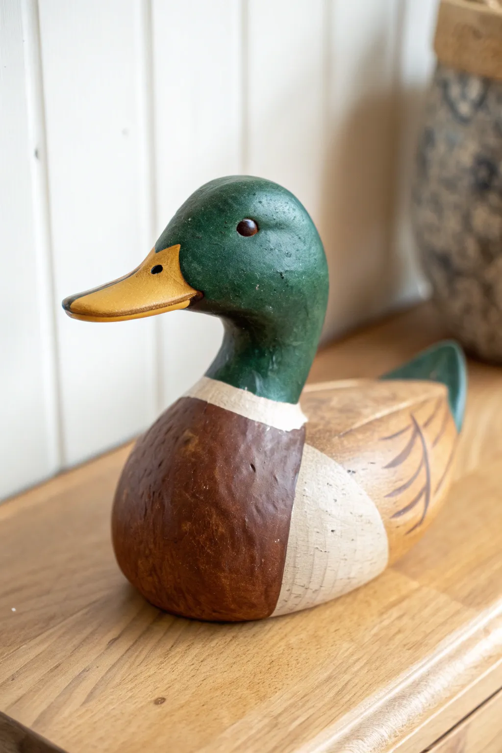 Simple color-block mallard duck sculpture in clay, bold greens and browns on a minimal backdrop