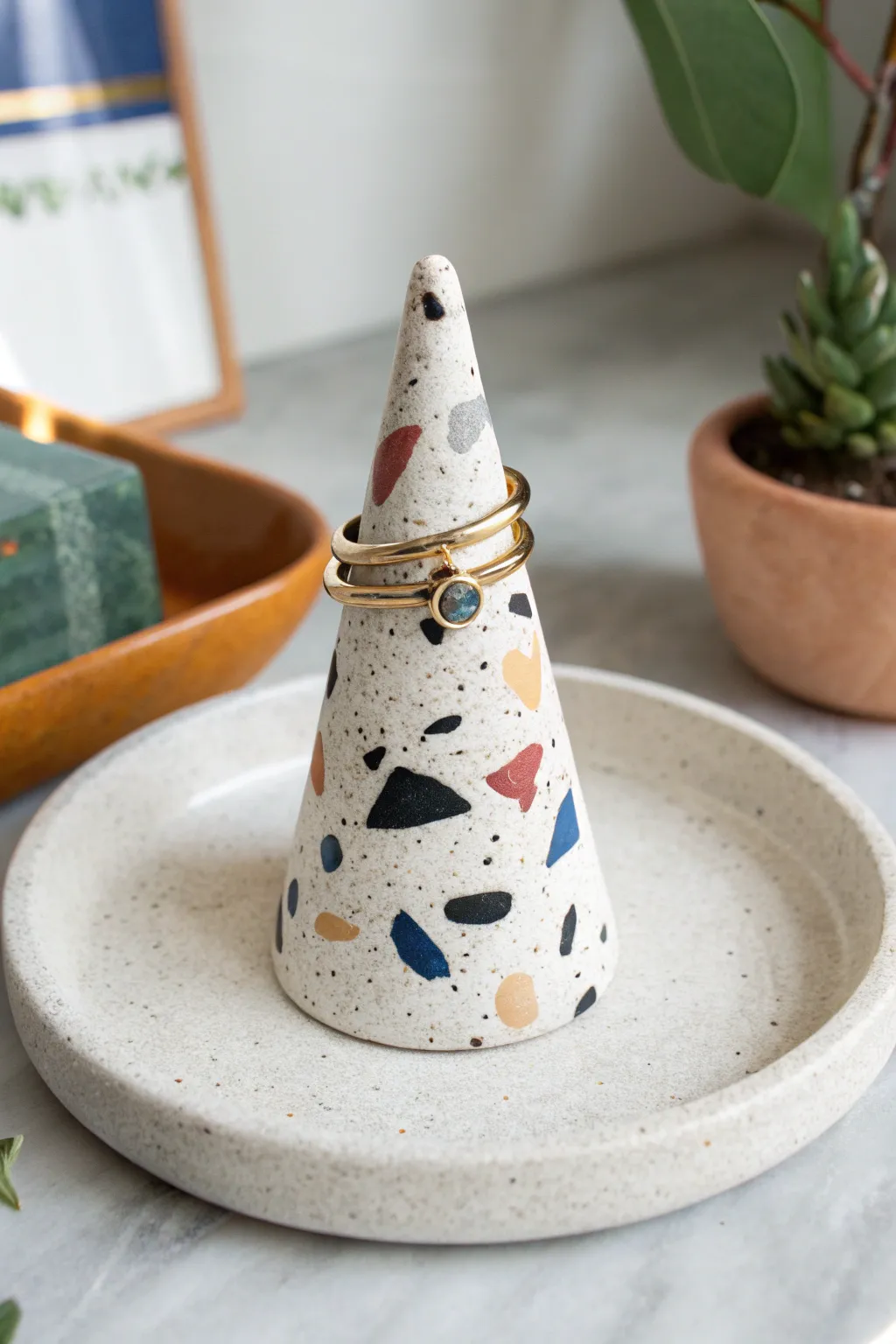 Terrazzo-speckled clay ring stand with bold pops of color, minimalist and boho chic.