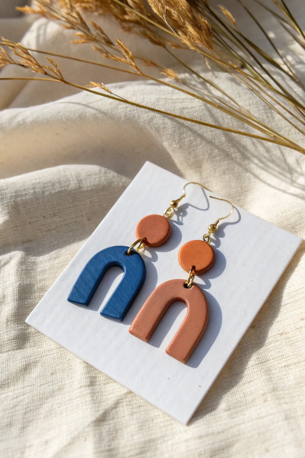 Minimalist polymer clay arches in bold cobalt and terracotta, handmade and featherlight.