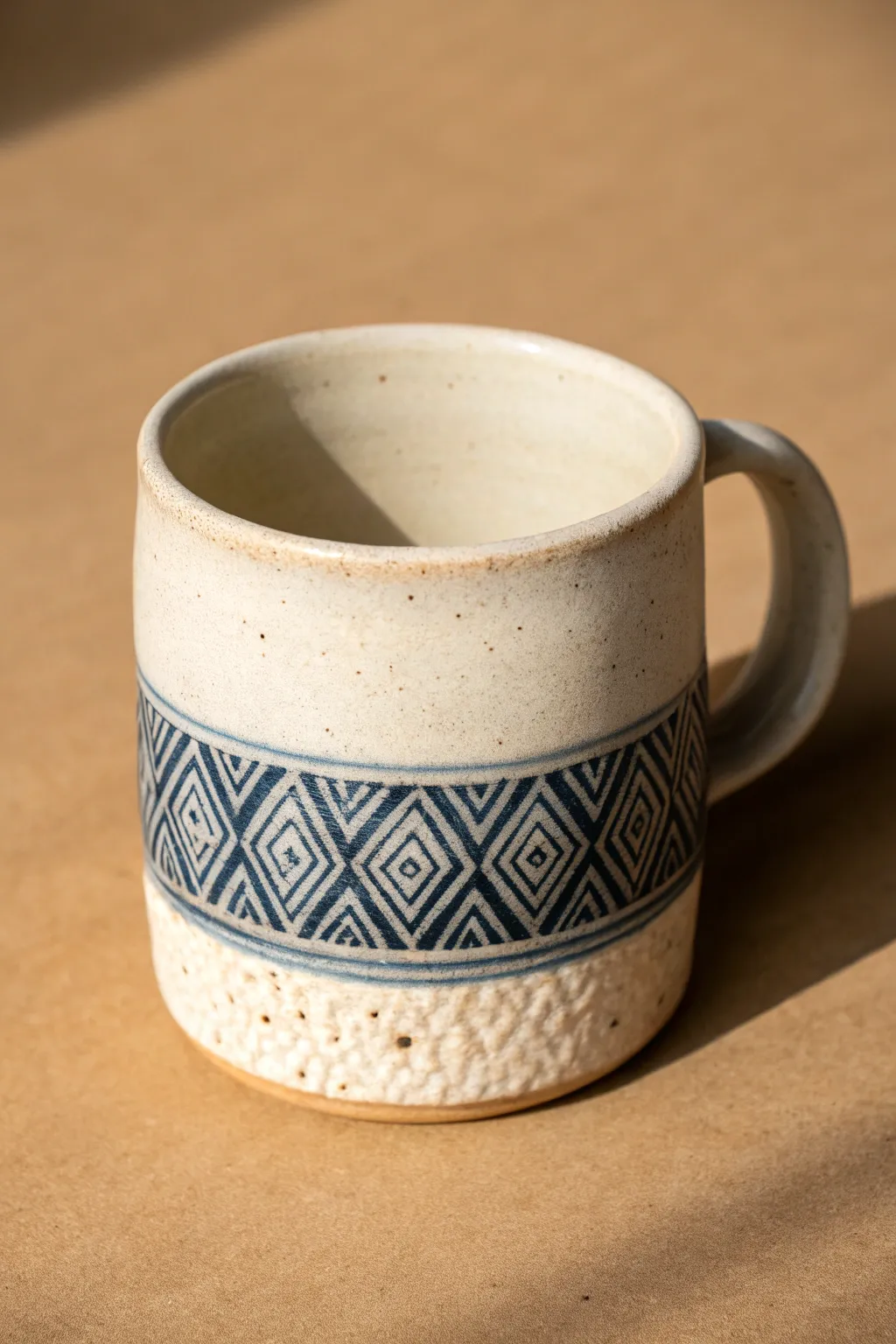 Rolled texture band adds instant pattern to a simple mug, highlighted by soft side light.