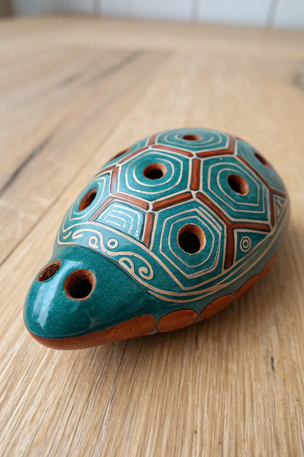 Turtle shell clay whistle with subtle finger holes, bold glaze, minimalist boho styling.