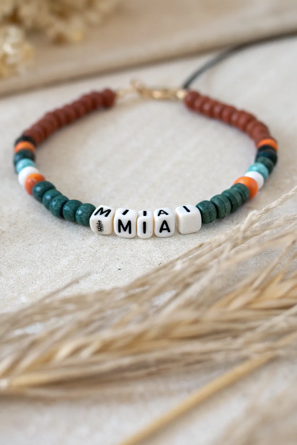 Minimal letter bead name bracelet with terracotta and teal heishi beads, bold yet soft and handmade.