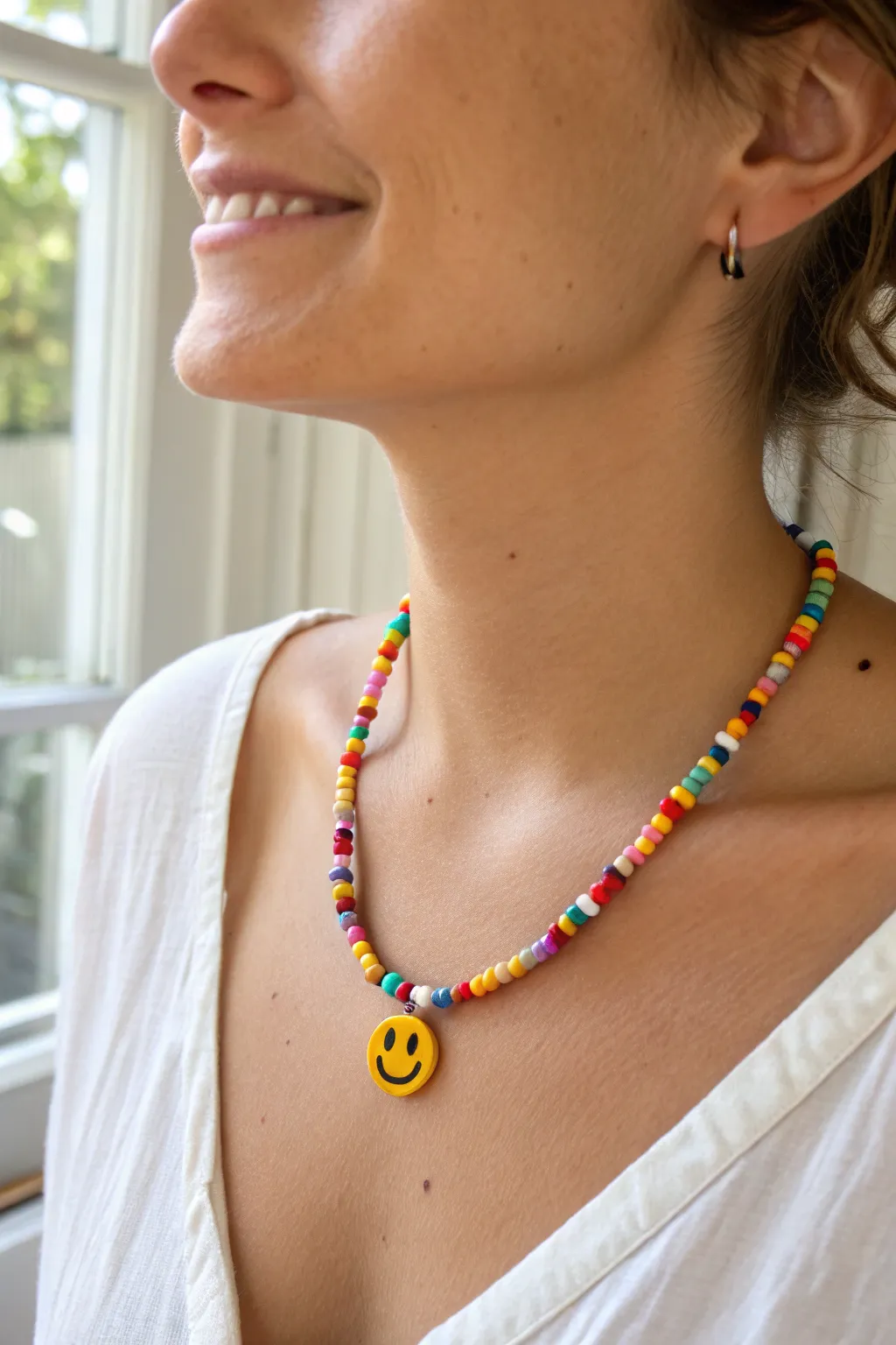 Bright heishi choker with a centered smiley charm, easy cute clay bead necklace inspo.