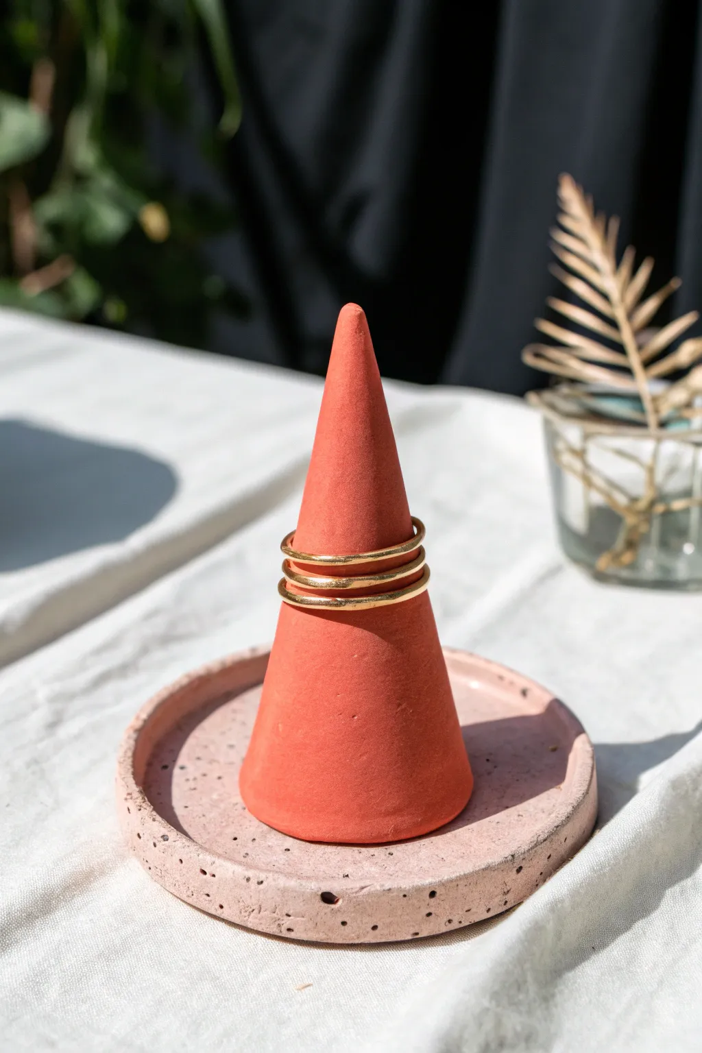 Bold coral air-dry clay ring cone holder with stacked gold rings, minimalist boho charm.