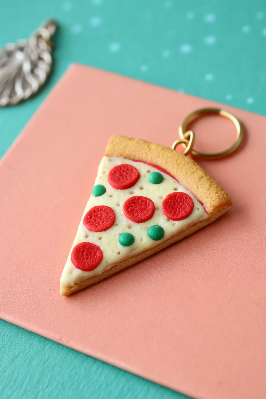 Tiny bake-clay pizza charm with playful dot toppings, bold contrast, minimalist Scandinavian-boho mood