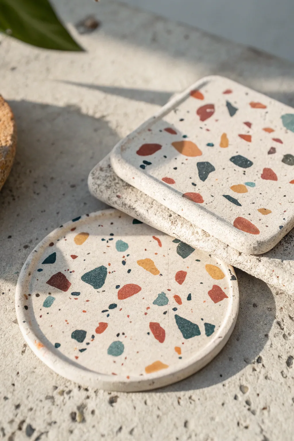Speckled terrazzo air-dry clay coasters in bold modern tones, minimalist flat-lay