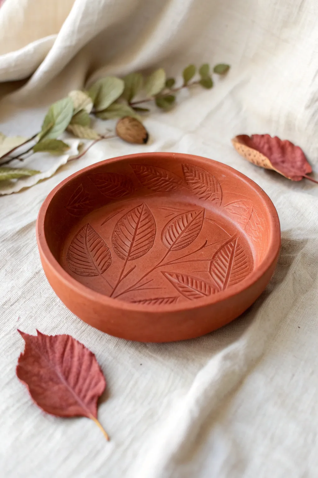 Leaf-stamped red clay catchall with warm terracotta tones, minimal boho styling and crisp texture.