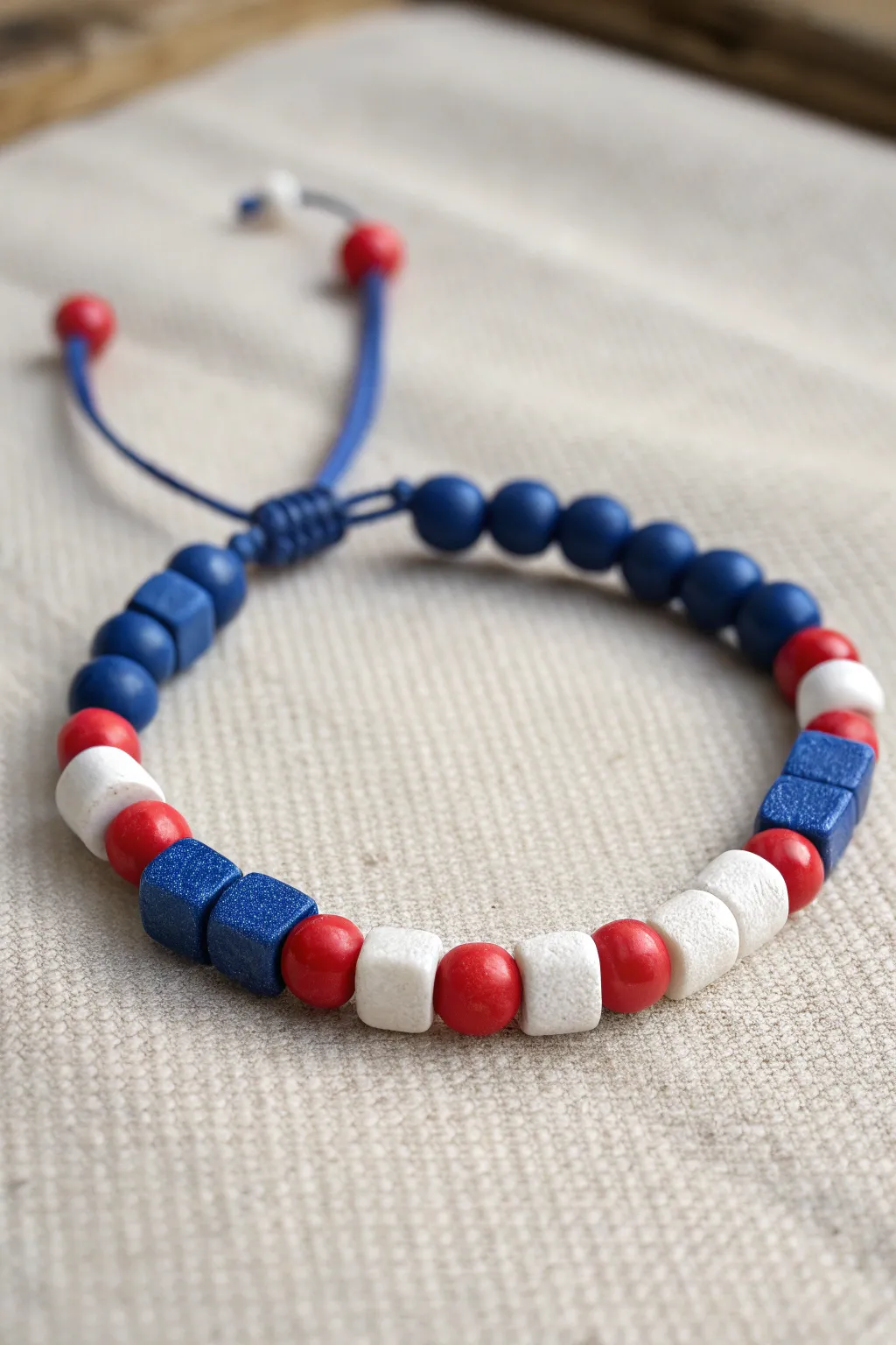 Flag-inspired clay bead bracelet with bold blue and crisp red-white blocks, clean and modern.