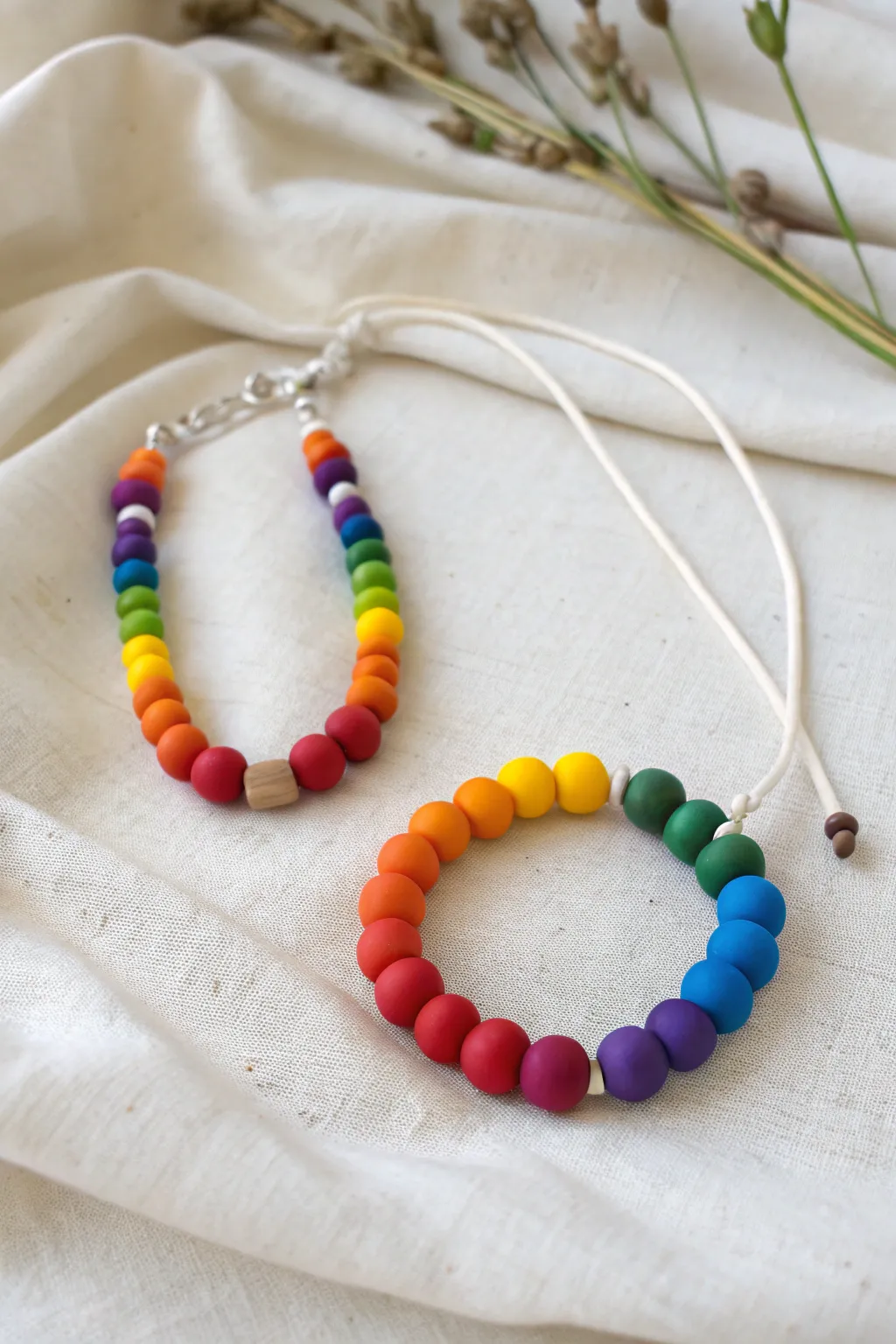 Rainbow clay bead bracelet and necklace set in bold colors on a calm neutral backdrop
