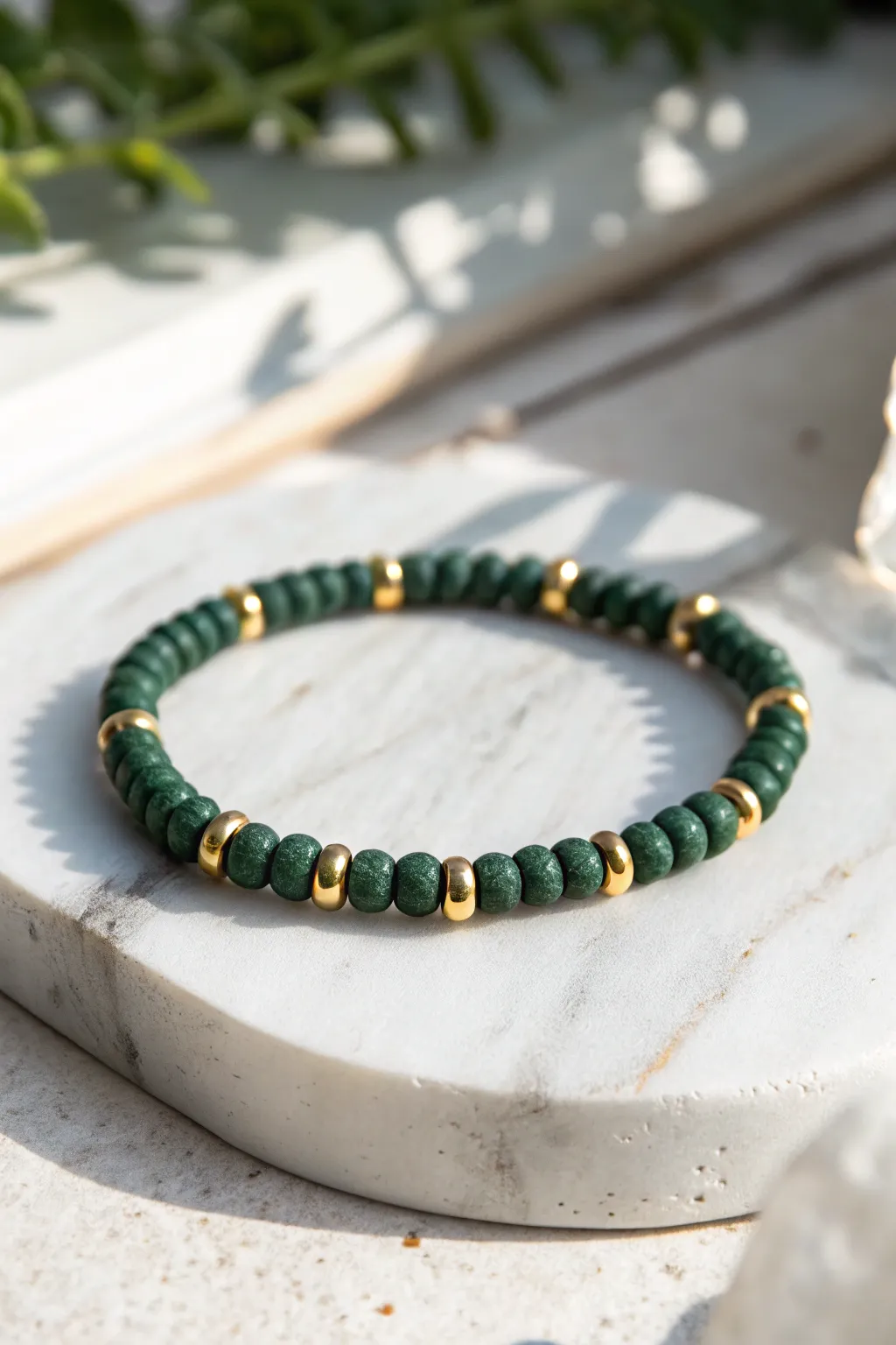 Forest green heishi bracelet with simple gold spacers for a bold, boho-minimal look.