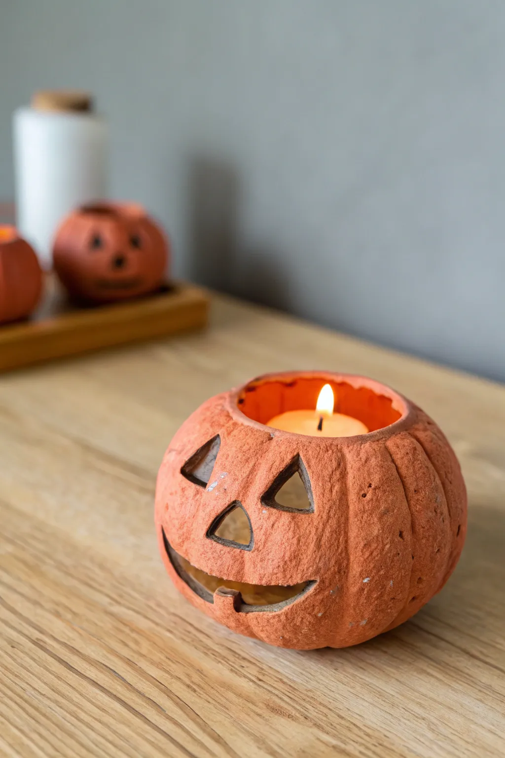 Cozy air dry clay pumpkin tea light holder glowing softly, perfect for minimalist Halloween decor.
