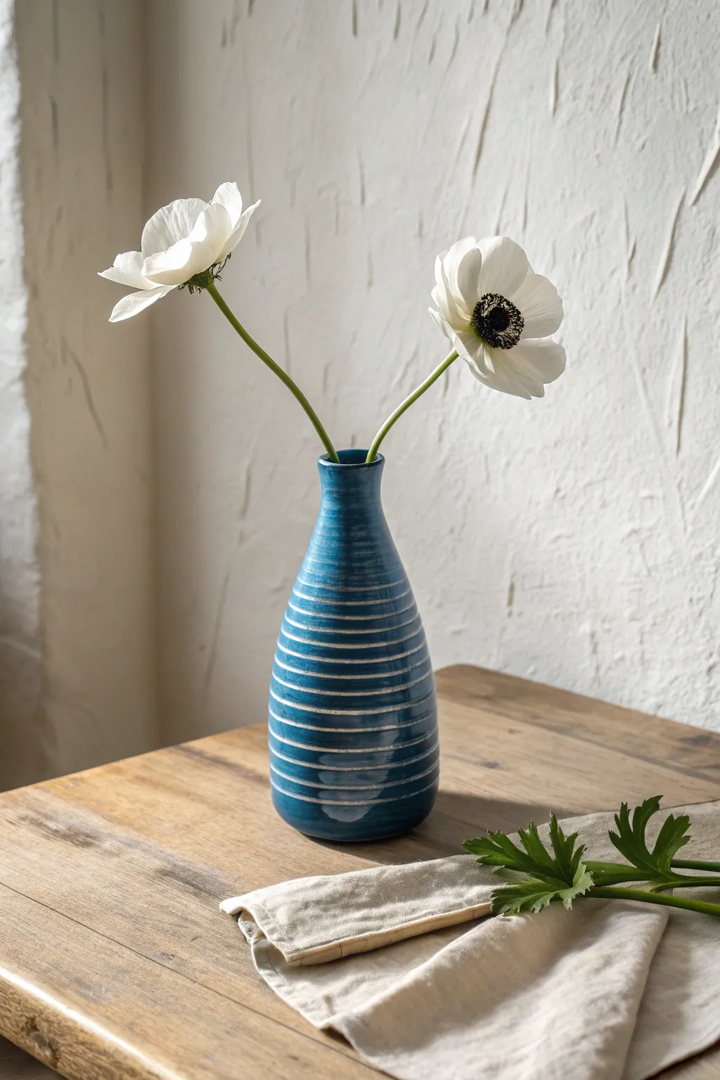 A bold coil-built bud vase with proud lines and a single stem for airy minimal charm.