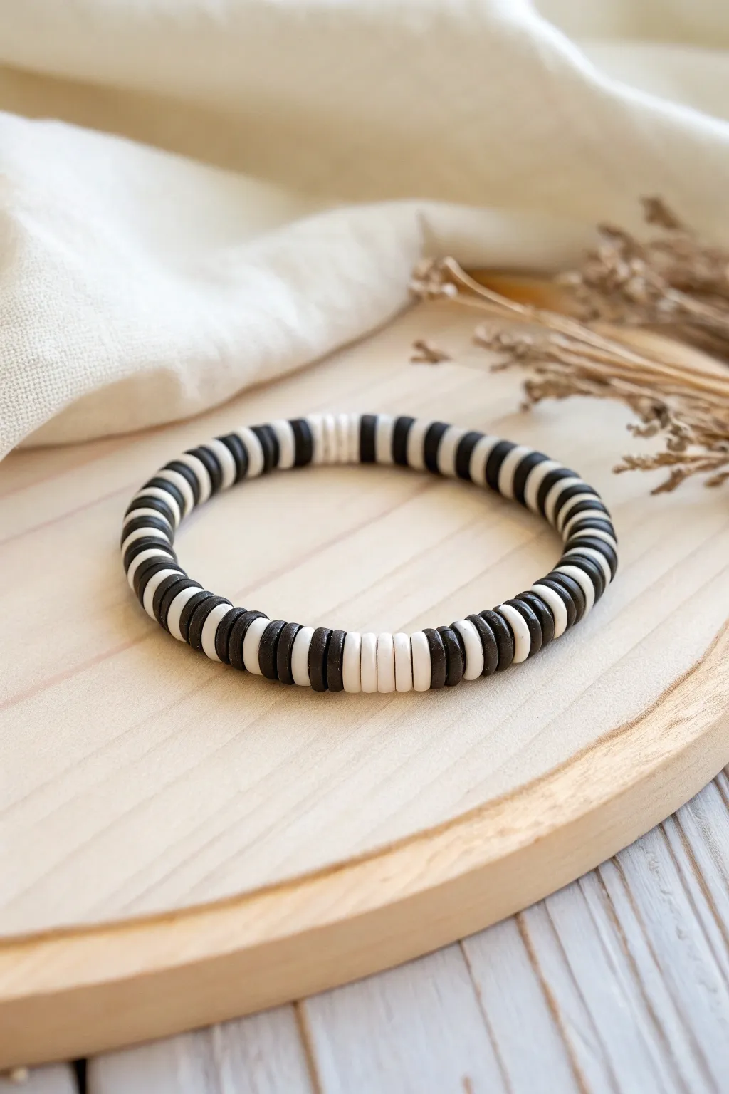 Bold black-and-white heishi clay bead bracelet with graphic stripes, minimalist boho statement.