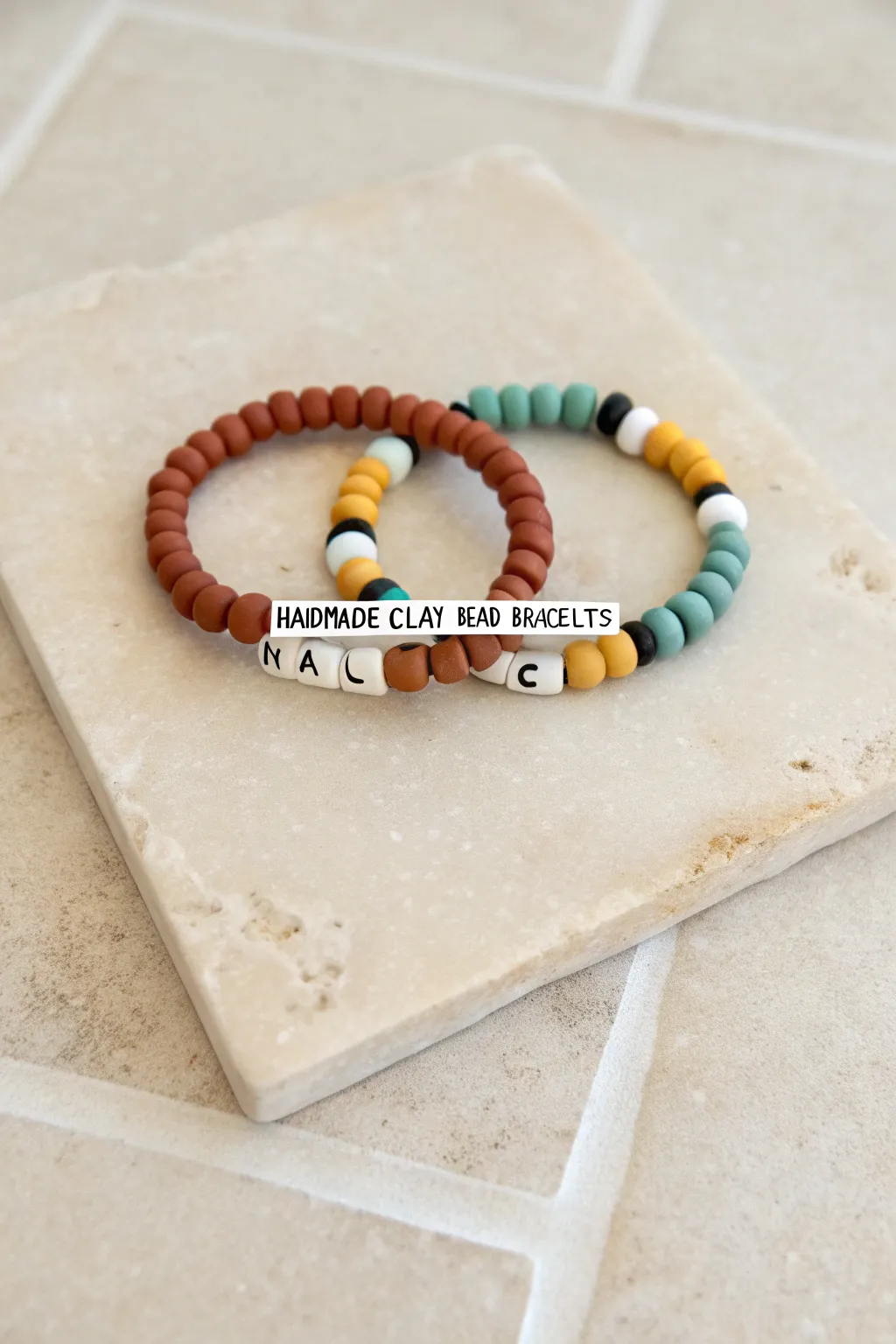 Matching name bracelets with identical heishi borders, a simple DIY look that feels truly coordinated.