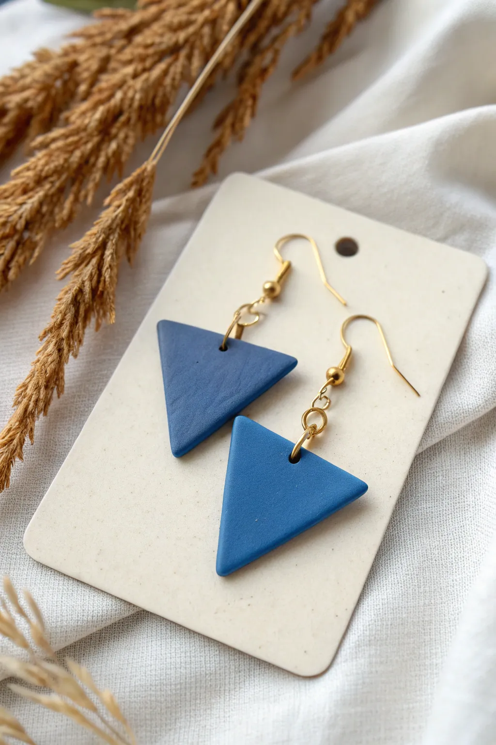 Simple triangle dangles in bold color, a minimalist polymer clay earring idea for beginners.