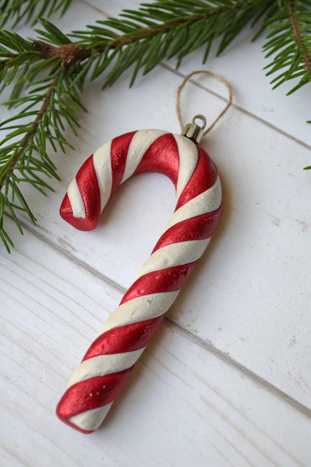 Bold red-and-white candy cane swirl clay ornament, minimalist yet festive and handmade