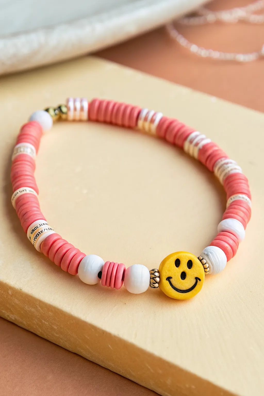 Playful heishi bracelet with smiley accent beads adds a bright break in minimalist style.