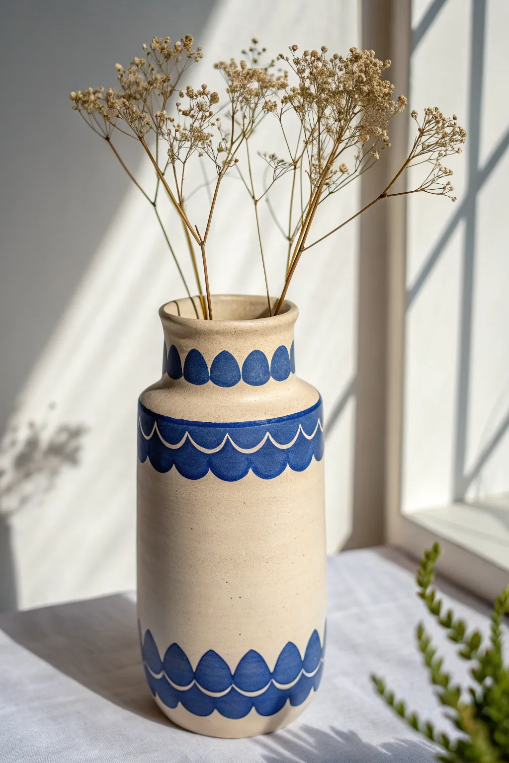 Minimal simple polymer clay vase with bold scalloped rim accent and airy dried stems.