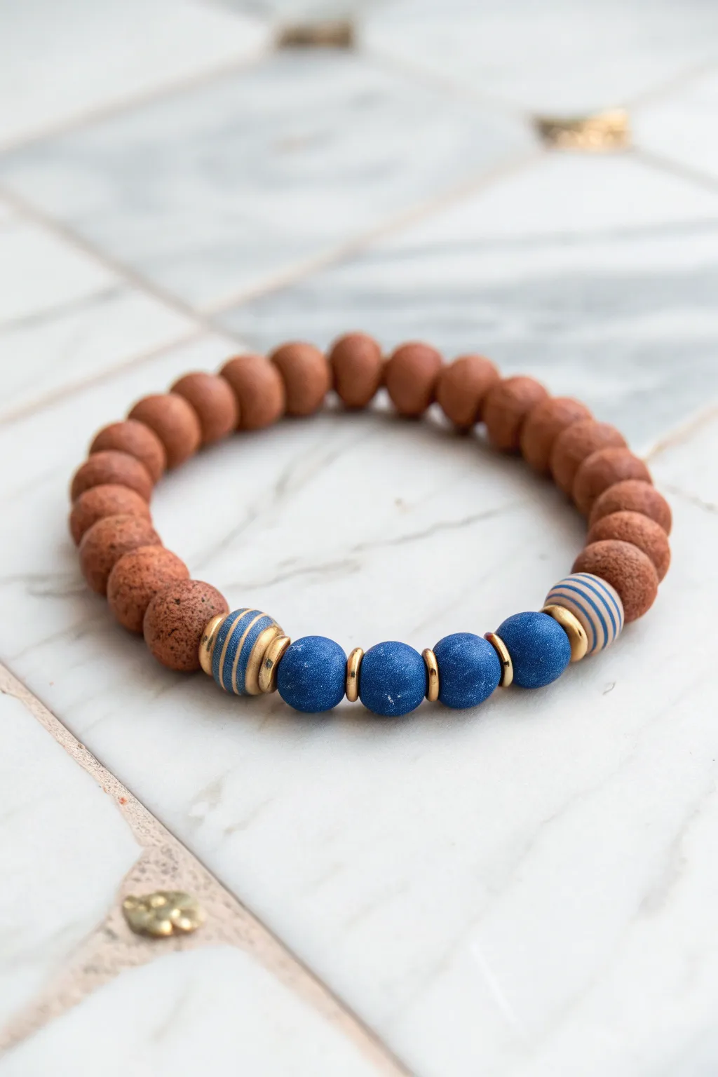 Simple striped clay bead bracelet in bold color blocks on pale marble, minimalist boho charm.