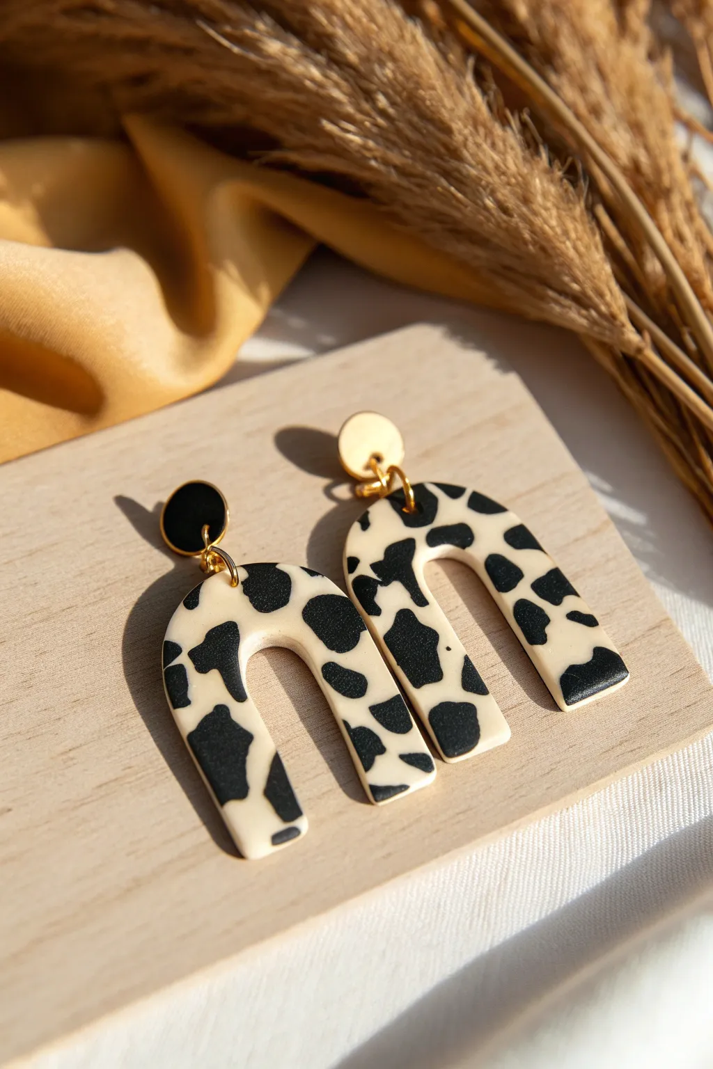 Bold cow print clay statement earring with satin sheen, modern western flair for minimal boho style