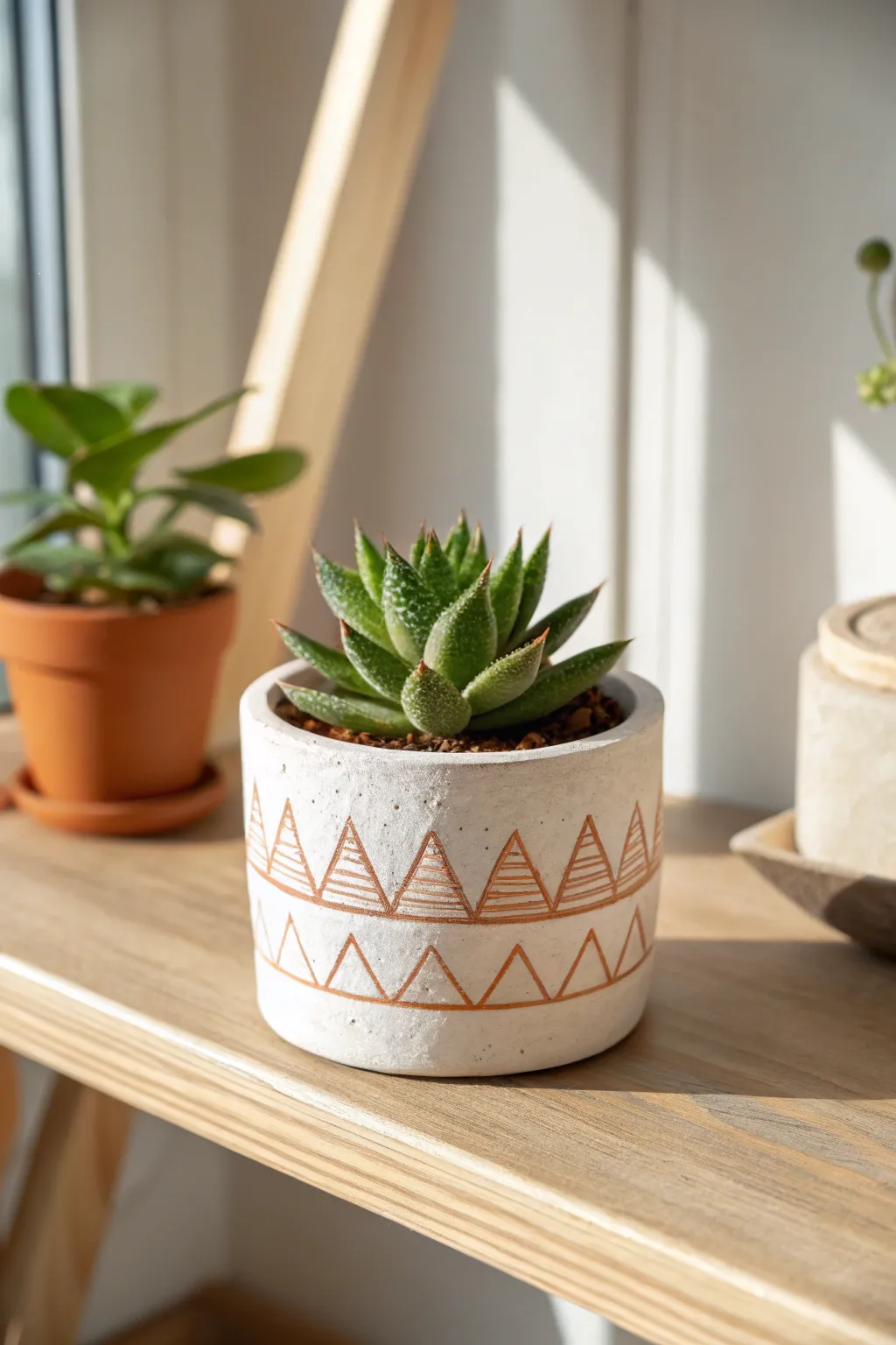 Minimal air-dry clay planter with geometric pattern and a fresh succulent, cozy modern shelf styling