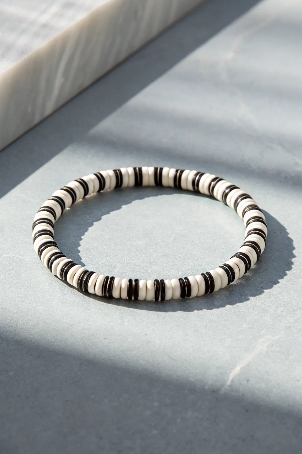 Monochrome heishi bracelet with bold graphic pattern, minimalist and modern, high-contrast beauty.